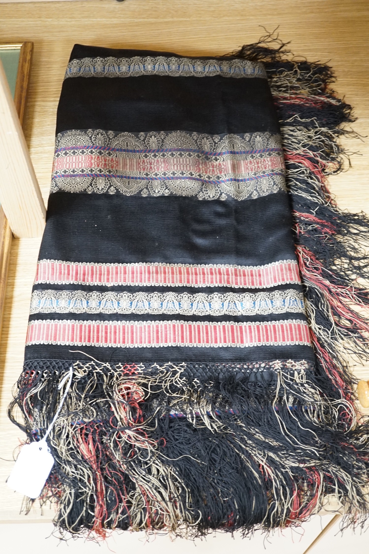 A Victorian black silk shawl woven, woven with multi-coloured Paisley designed stripes bordered with a silk multi-coloured fringe, 184cms square (not including fringe)
